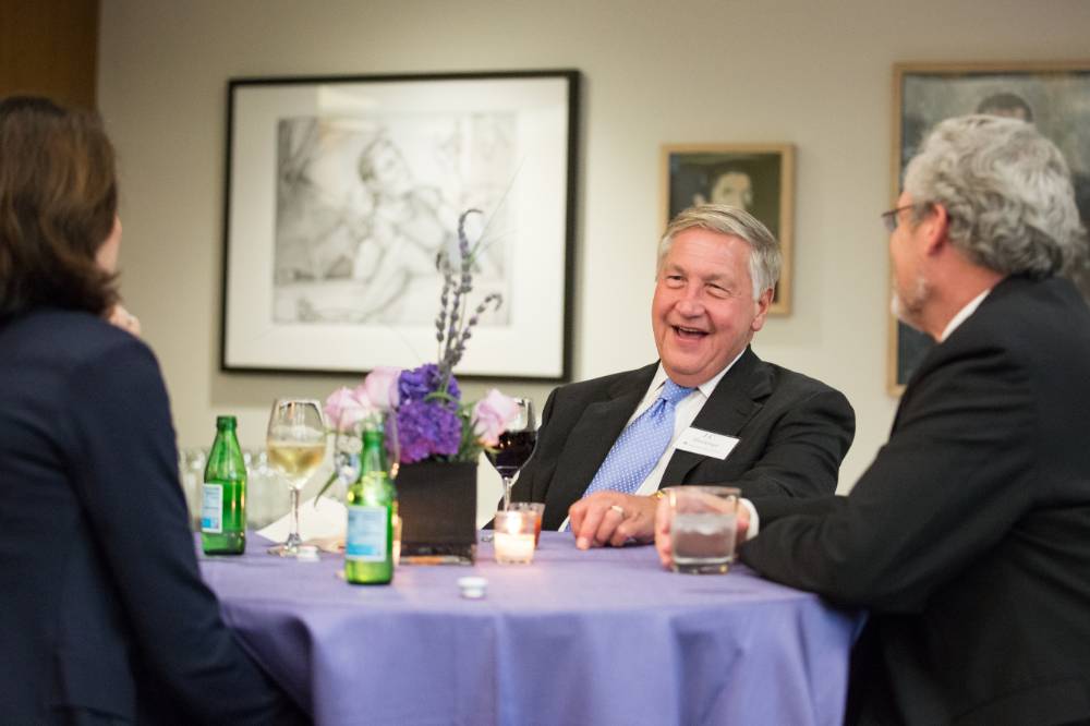 J.C. Huizenga laughing with two other guests at a table.